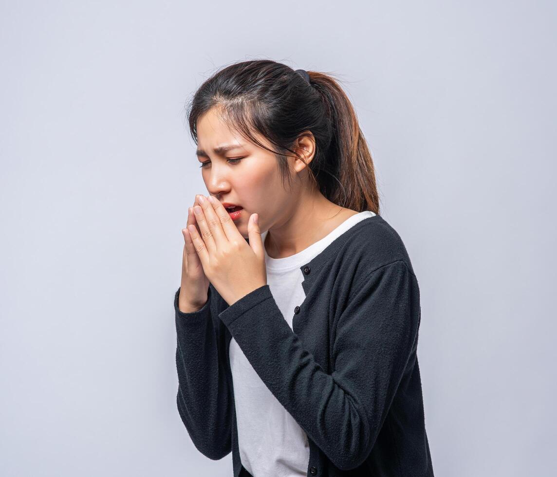 une femme toussant et se couvrant la bouche avec sa main photo