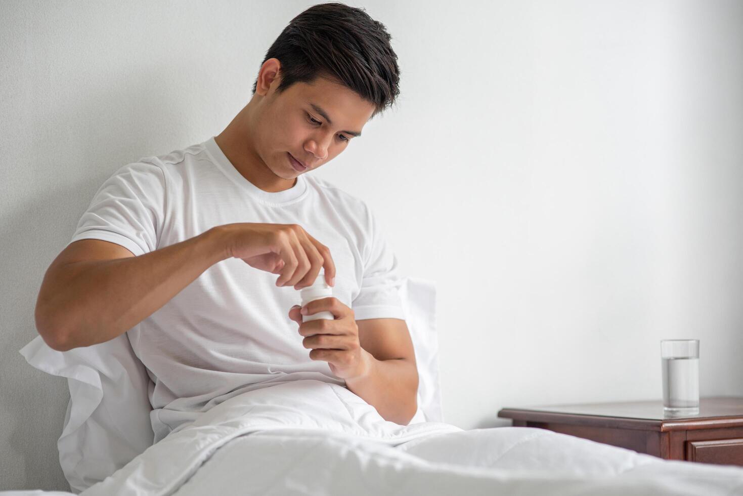 un homme qui ne se sent pas bien sur le canapé et qui s'apprête à prendre des antibiotiques. photo