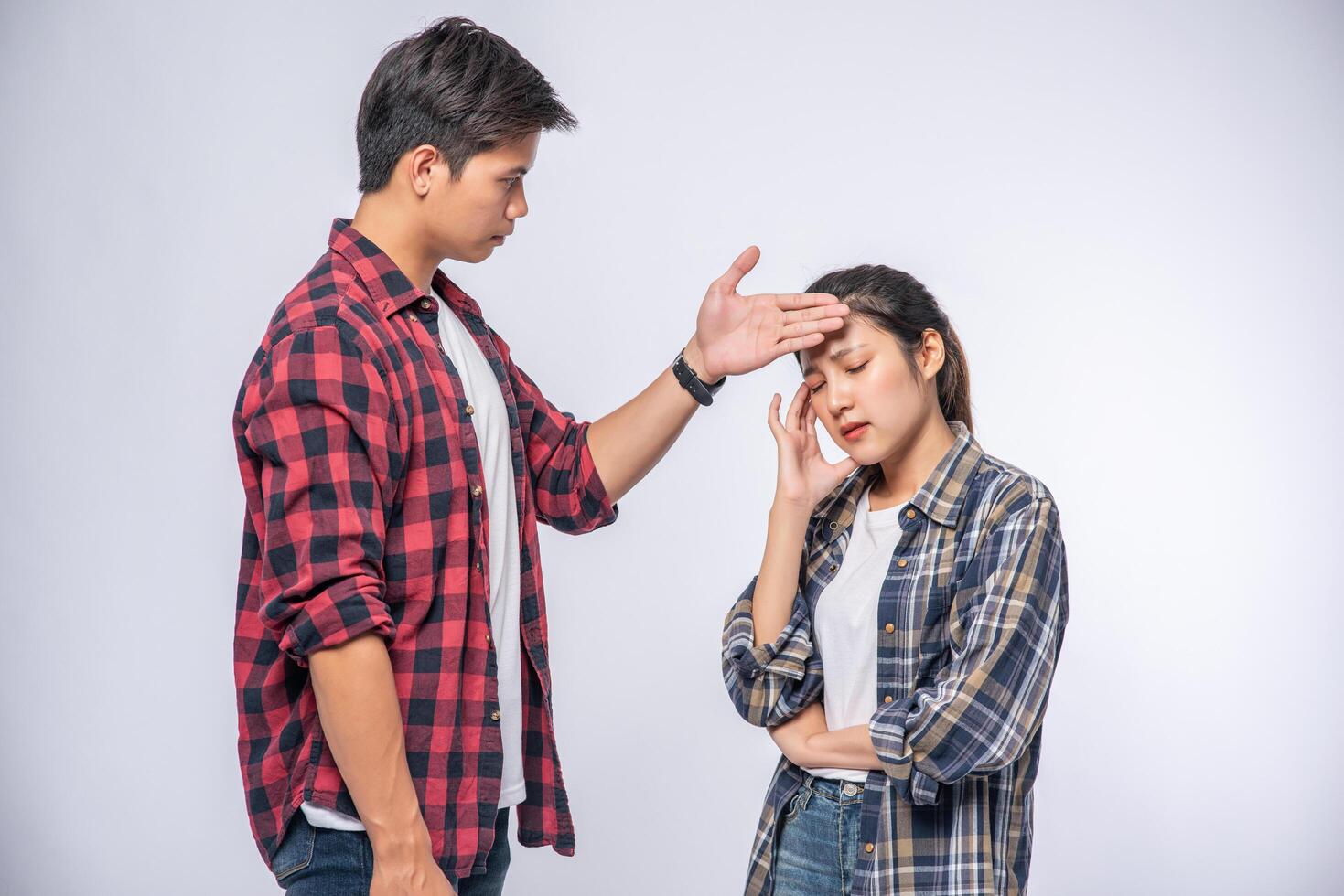 une femme malade avait un homme qui regardait et touchait son front. photo