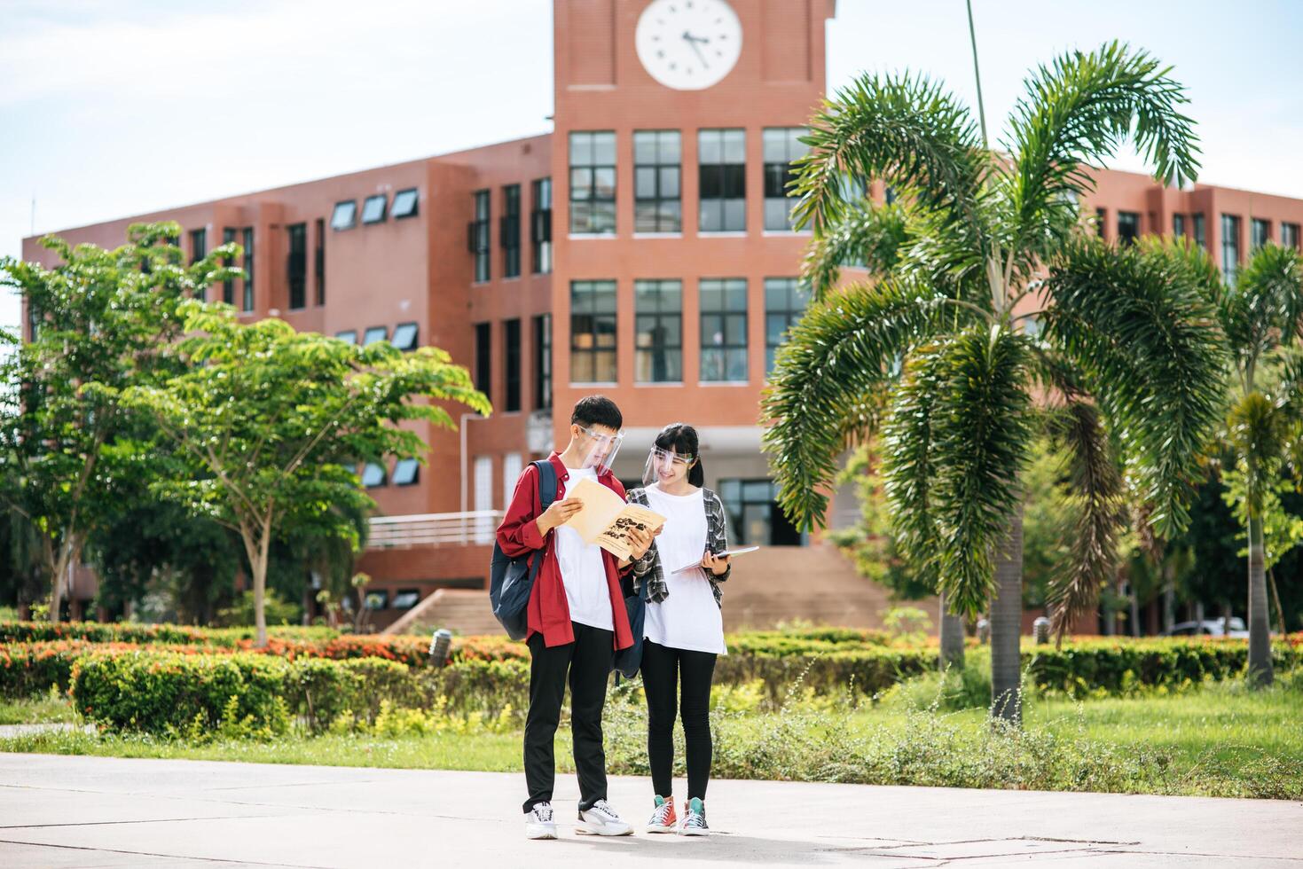 les étudiants masculins et féminins portent un visage froid et se tiennent devant l'université. photo