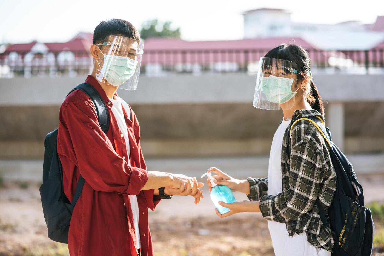 les étudiants masculins et féminins portent des masques et pressent le gel pour se laver les mains. photo