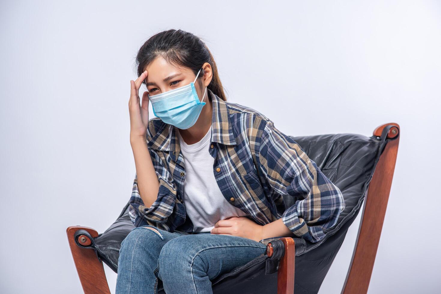 la femme était malade, s'assit sur une chaise et toucha sa tête avec sa main. photo