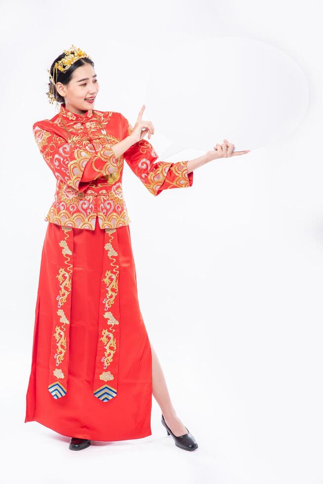 une femme porte un costume cheongsam et une chaussure noire heureuse d'avoir de nouvelles choses pour surprendre le nouvel an chinois photo