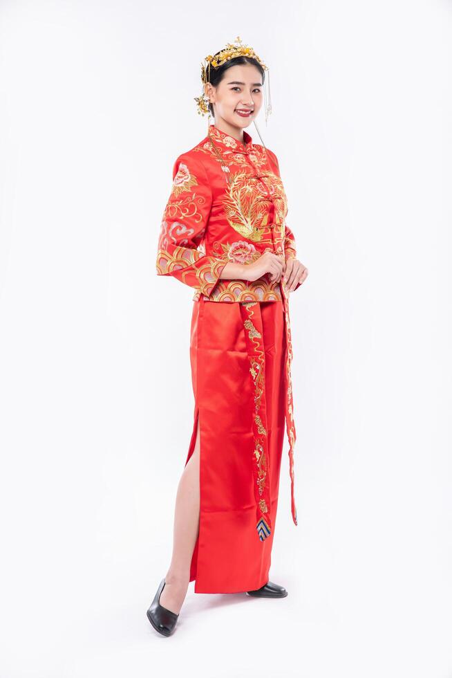 femme portant un costume cheongsam sourire pour accueillir les voyageurs faisant du shopping dans le nouvel an chinois photo