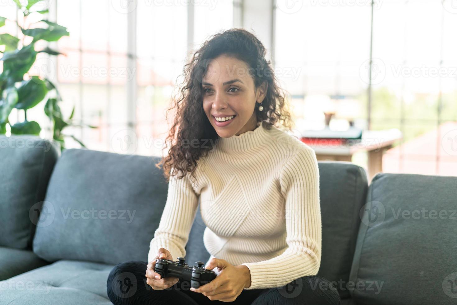 femme laitine jouant à des jeux vidéo avec les mains tenant le joystick photo