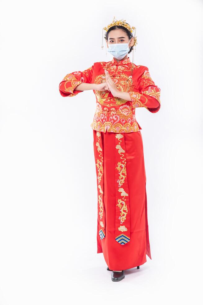 une femme porte un costume et un masque cheongsam respecte son père et sa mère au nouvel an chinois photo
