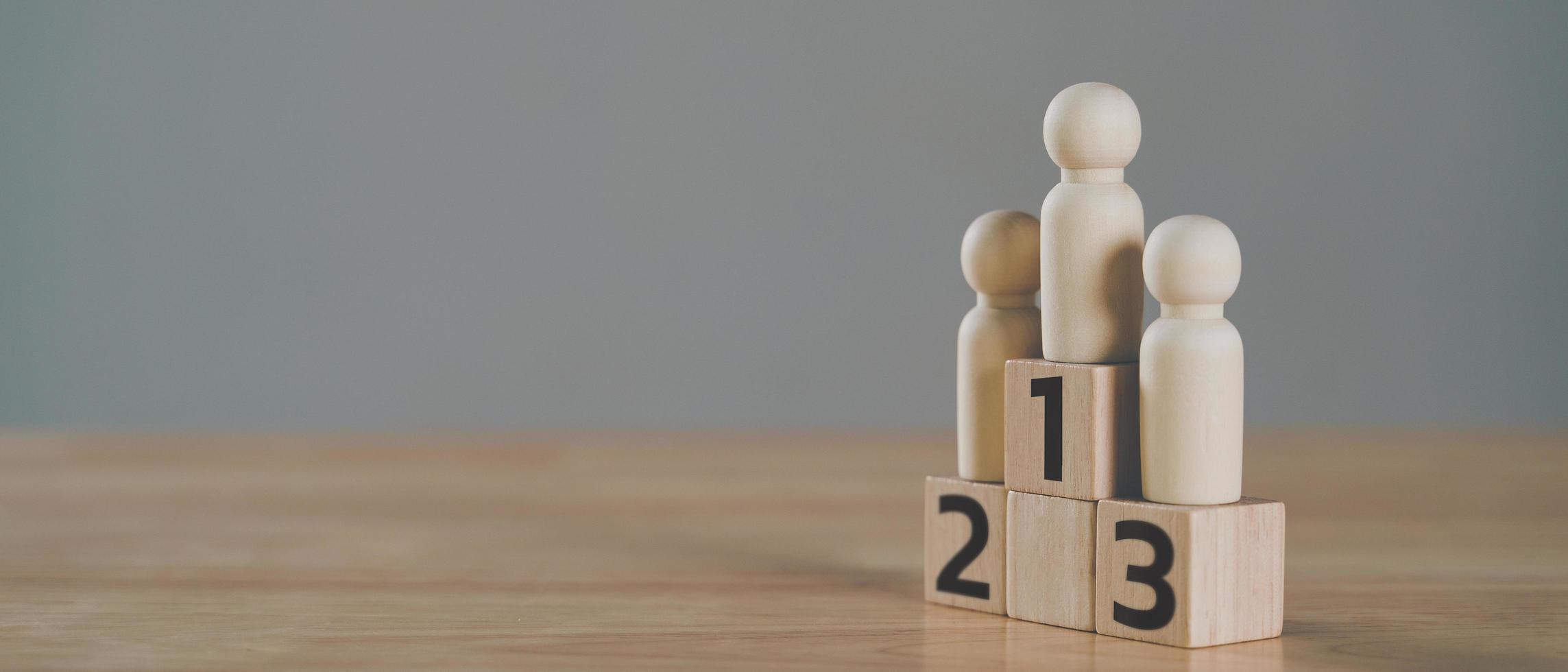 figurines en bois poupée de cheville debout sur le podium 1ère, 2ème, 3ème positions de blocs de cubes en bois avec espace de copie. concept de classement et de stratégie. photo