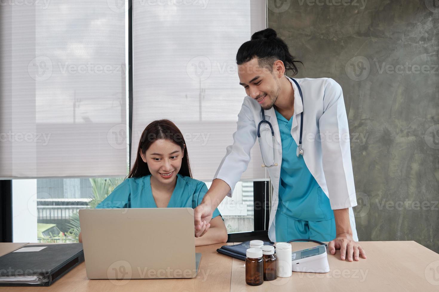 partenaires de l'équipe de soins de santé. deux jeunes médecins asiatiques en uniforme sont des collègues discutant des médicaments dans le bureau de la clinique de l'hôpital. les spécialistes sont des experts et des professionnels. photo