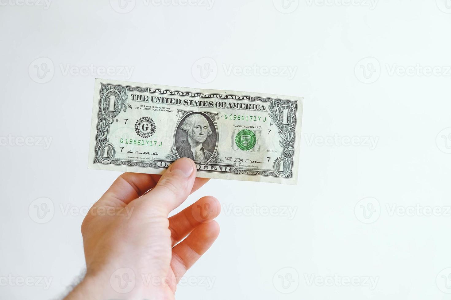 un dollar en main sur un fond blanc photo