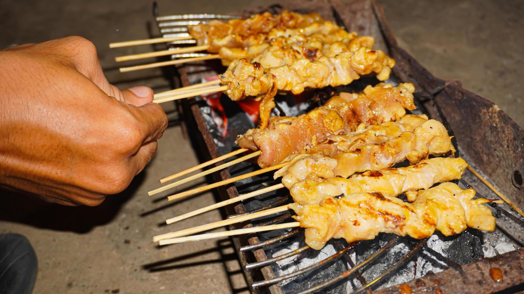 le processus de fabrication de la nourriture satay, grillée sur des charbons de bois photo