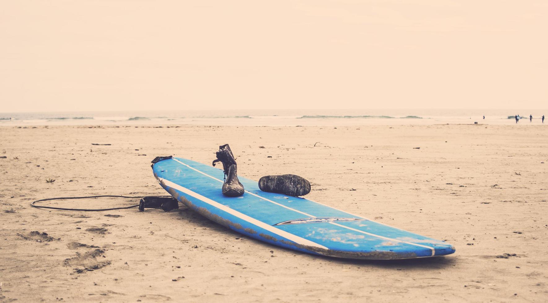 planche de surf bleu sur sable gris photo