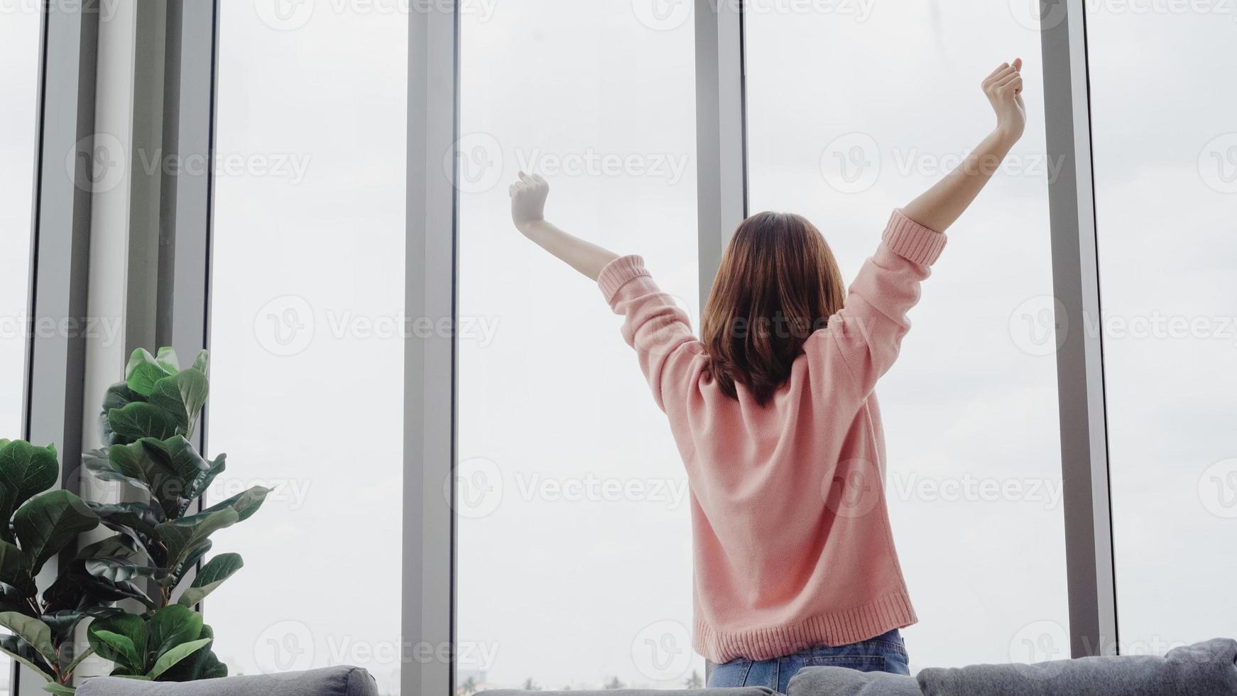 portrait de la belle femme asiatique étirant son corps et ses bras après son réveil se sentir somnolent dans sa chambre à la maison. femme de mode de vie au concept de maison. photo