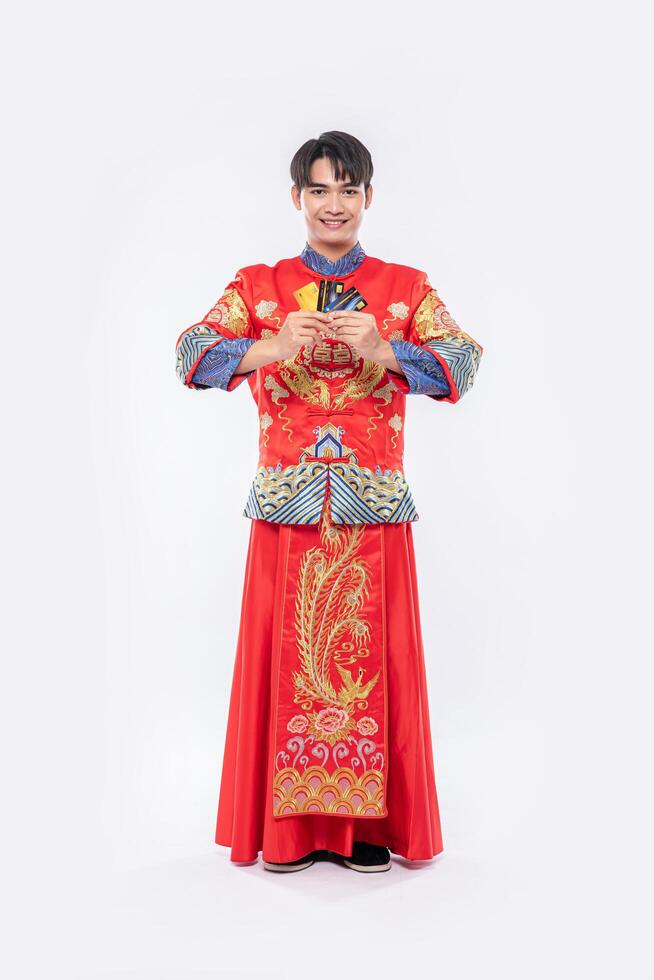 man wear cheongsam porte plusieurs cartes de crédit pour faire du shopping pendant le nouvel an chinois. photo