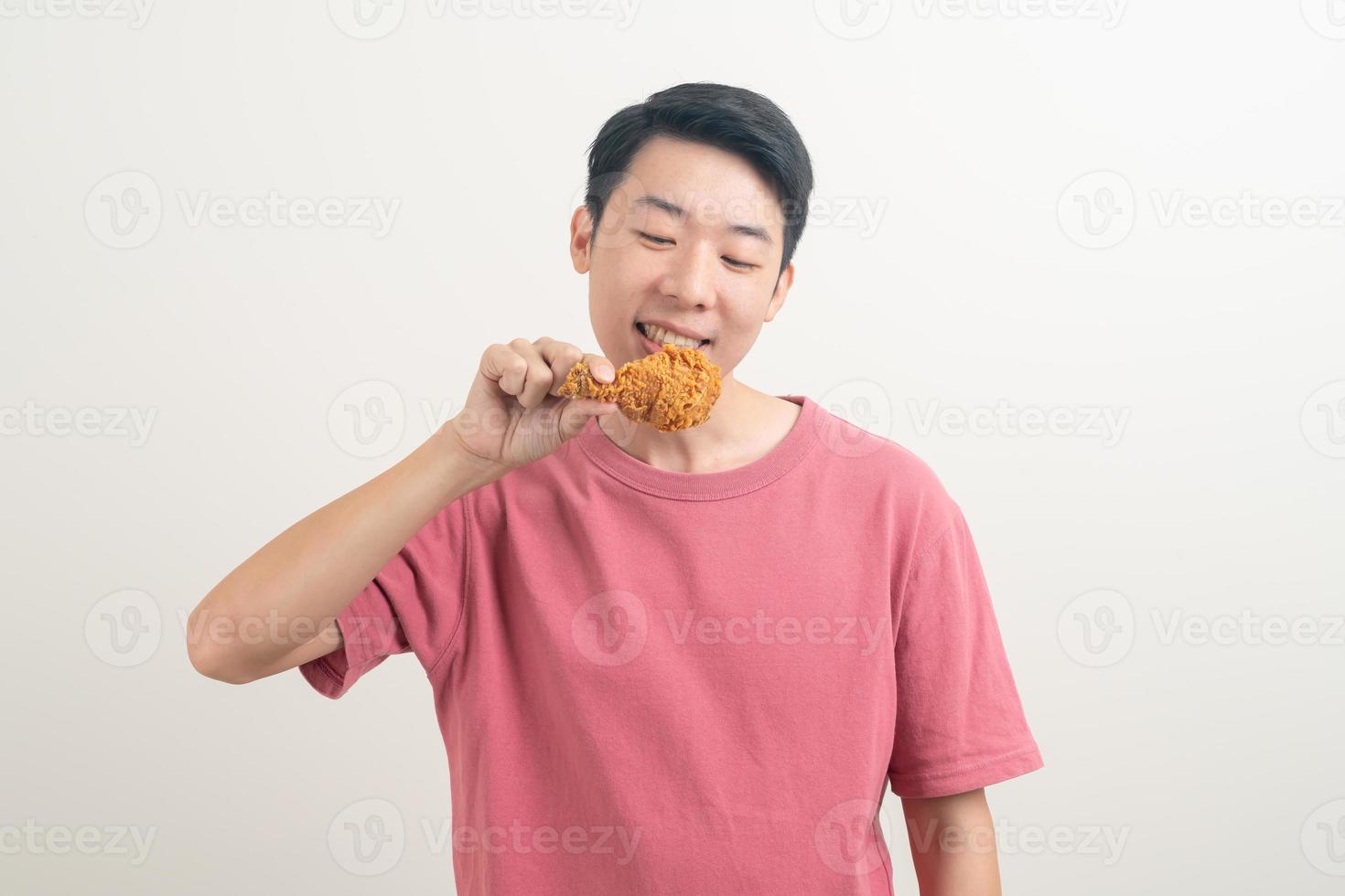jeune homme asiatique avec du poulet frit à portée de main photo