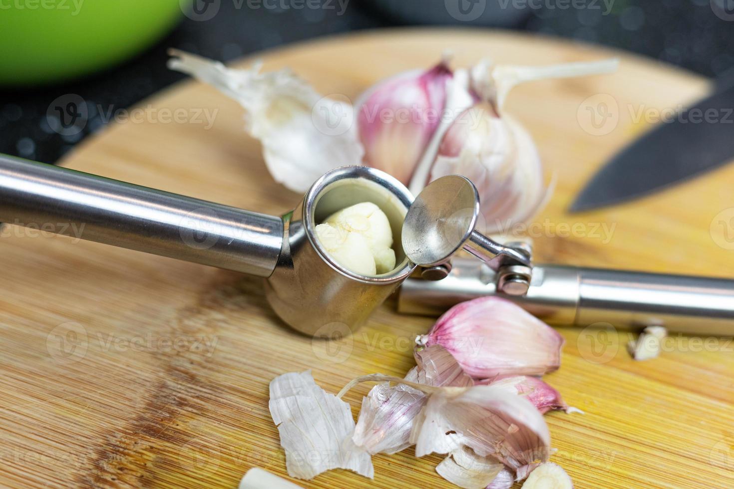 préparation de morceaux d'ail pour le jus. ail allongé sur une table en bois. photo