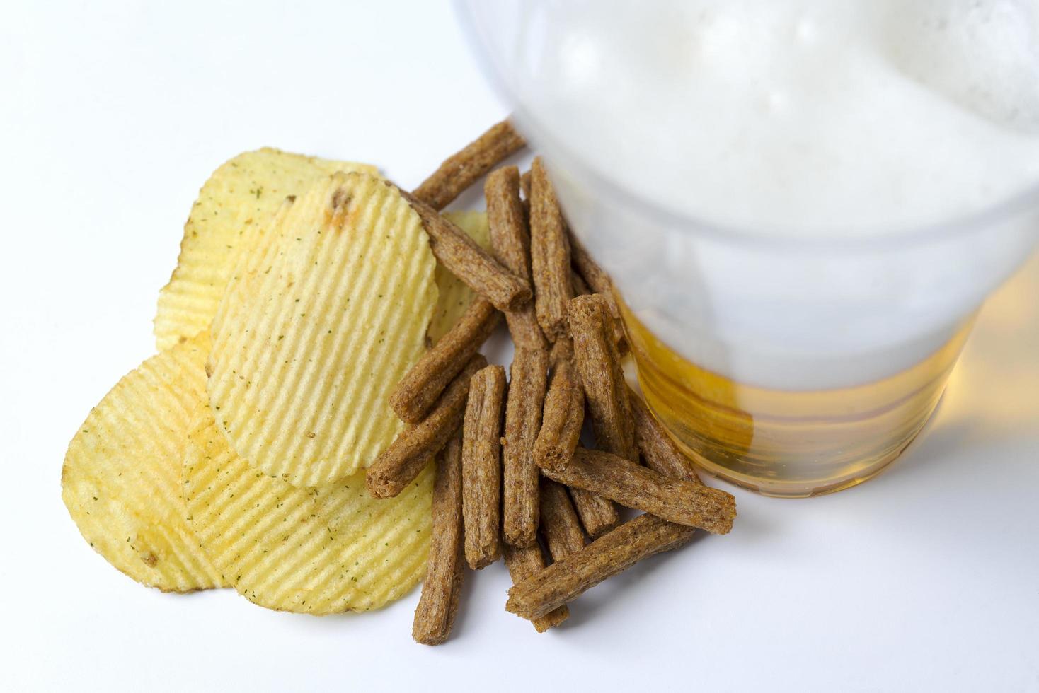 chips et craquelins sur fond blanc avec de la bière. photo