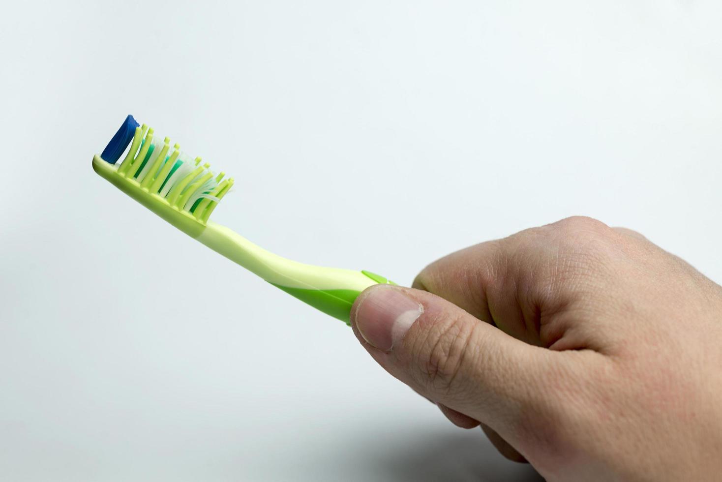 main tenant une brosse à dents. photo