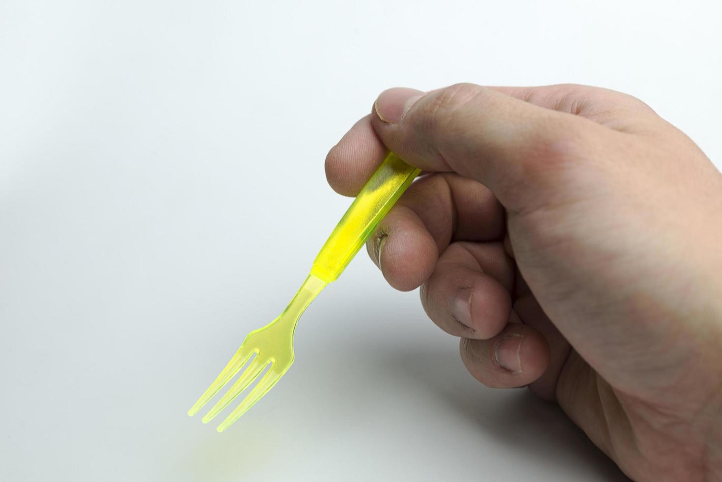 main tenant une fourchette en plastique. photo