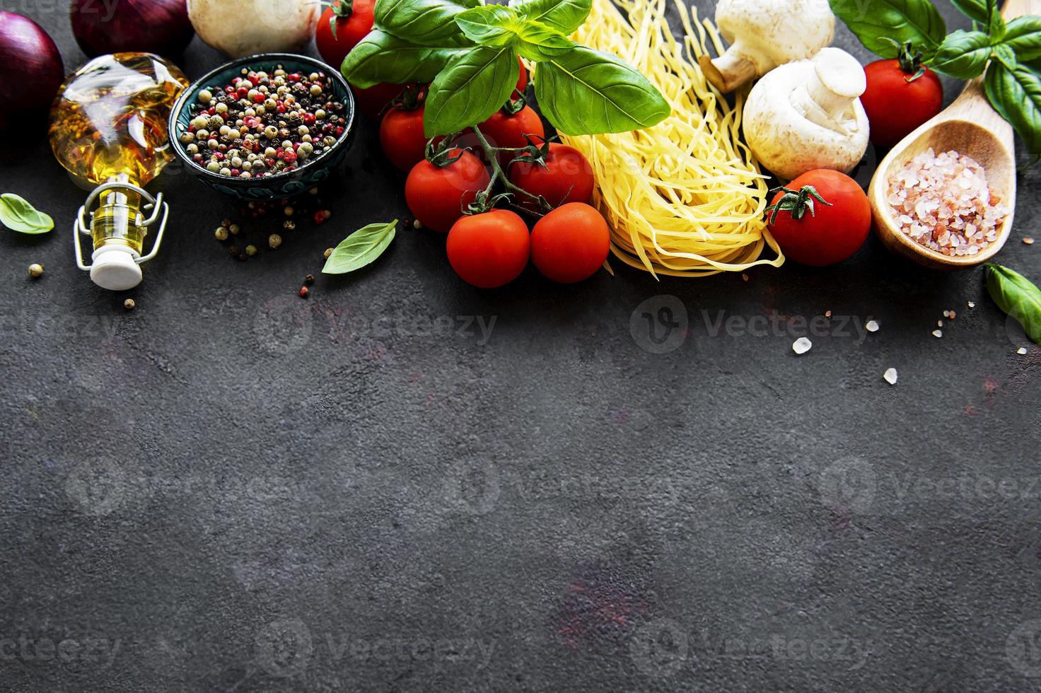 régime méditerranéen sain, ingrédients pour repas italien, spaghetti, tomates, basilic, huile d'olive, ail, poivrons sur fond noir photo