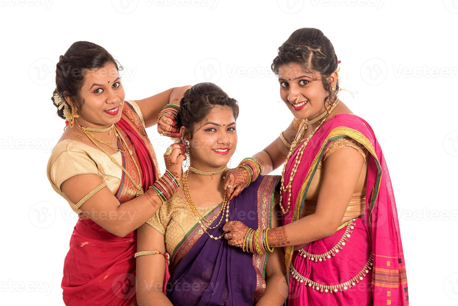 Belles jeunes filles indiennes traditionnelles en sari posant sur fond blanc photo