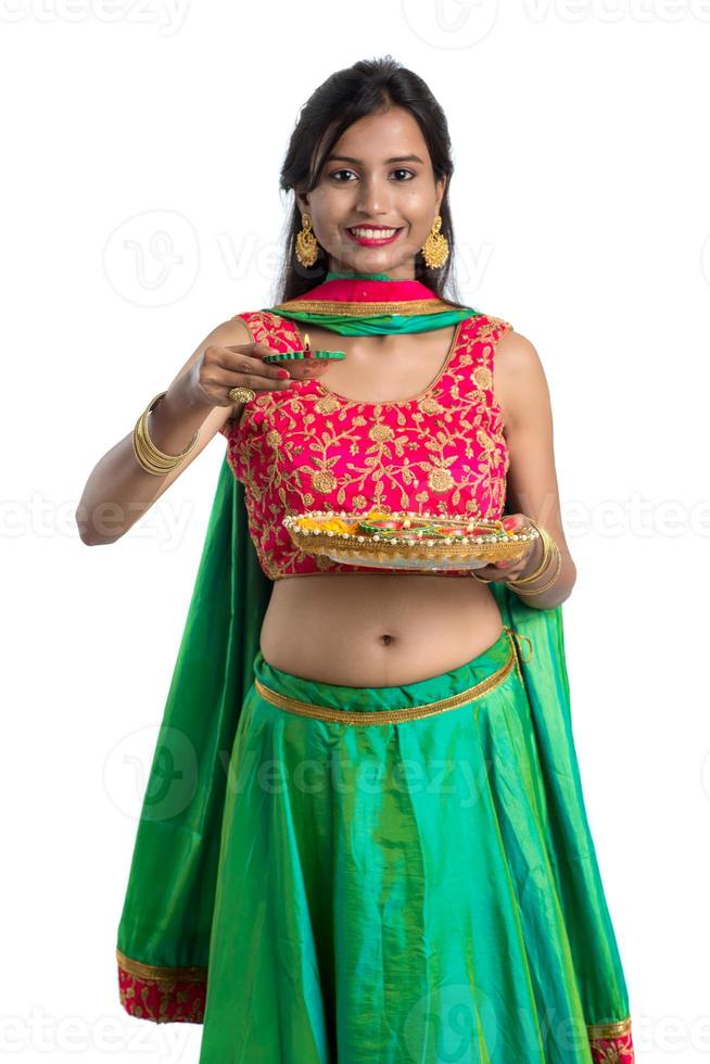 portrait d'une fille traditionnelle indienne tenant diya, fille célébrant diwali ou deepavali avec tenant une lampe à huile pendant le festival de la lumière sur fond blanc photo