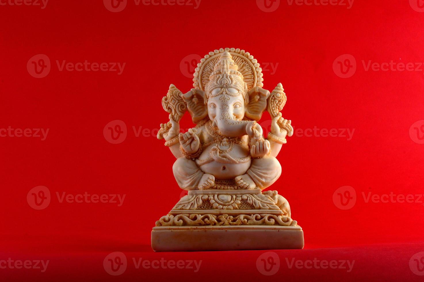 dieu hindou ganesha. idole de ganesha sur fond rouge photo