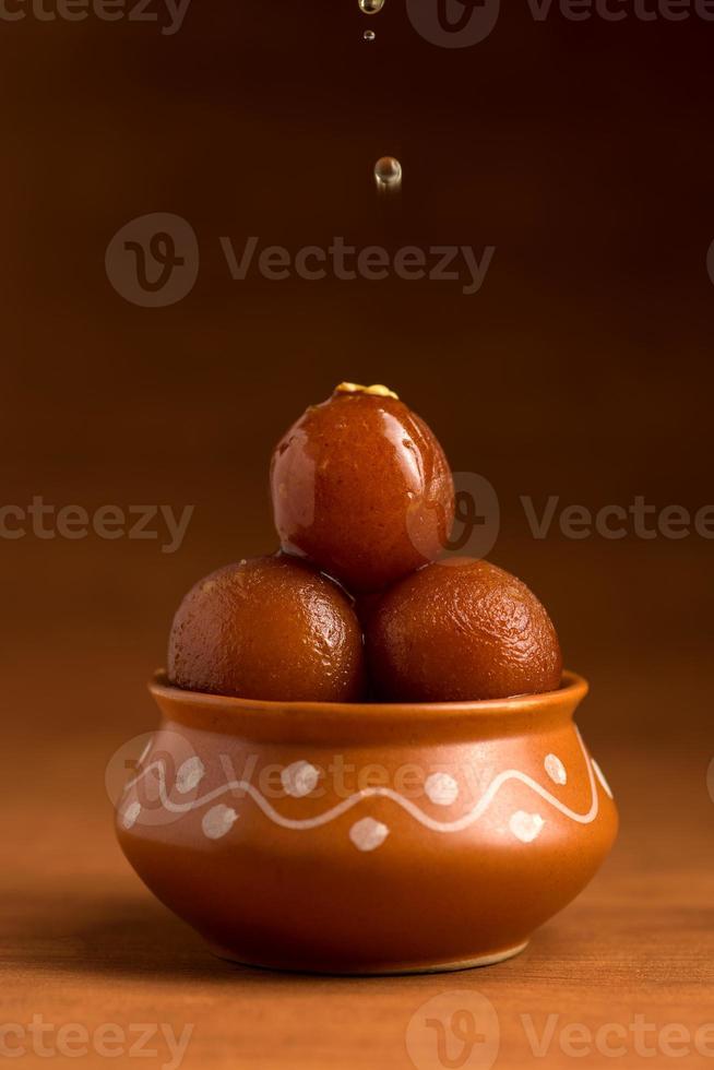 gulab jamun dans un pot en argile. dessert indien ou plat sucré photo