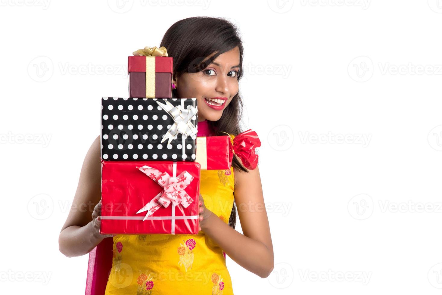 portrait de jeune fille indienne souriante heureuse tenant des coffrets cadeaux sur fond blanc. photo