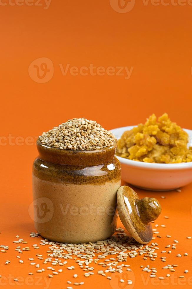 graines de sésame dans un pot en argile avec du jaggery dans un bol photo
