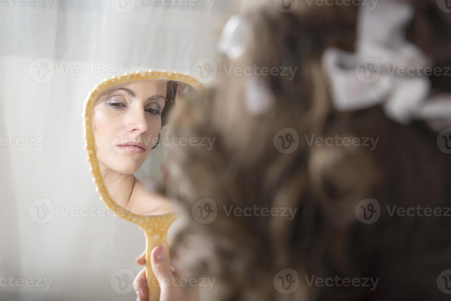 la fille se regarde dans le miroir. photo