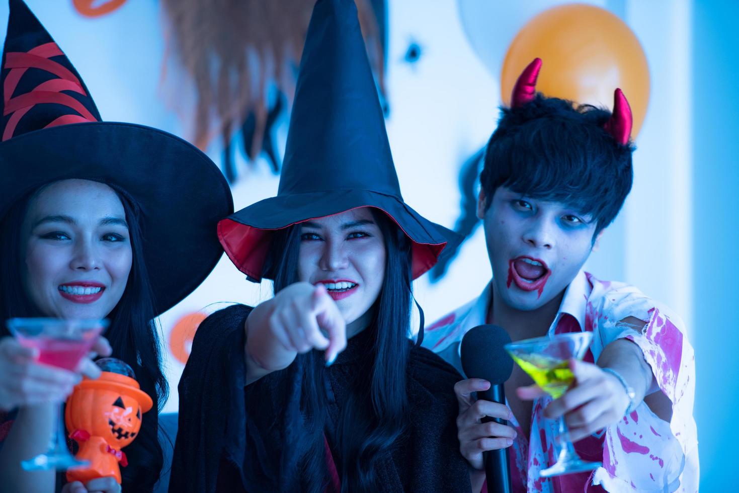 les jeunes asiatiques en costumes assistent à la fête d'halloween photo