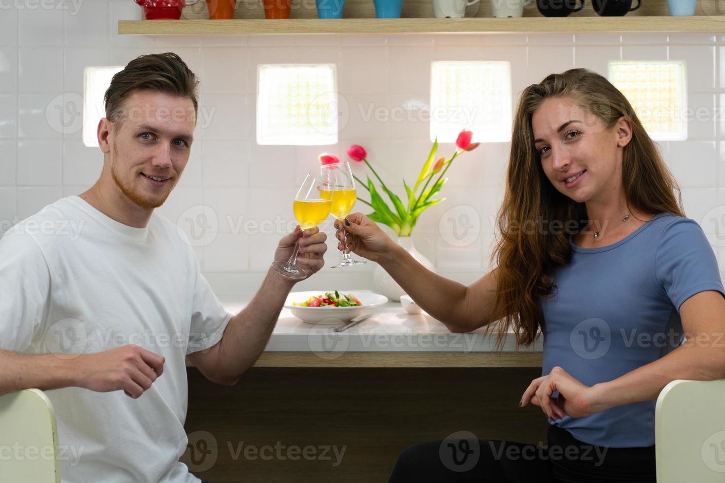 jeune couple caucasien assis à table ensemble et buvant du vin blanc pour le déjeuner le jour de l'anniversaire photo