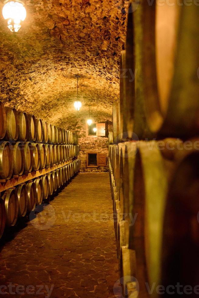 tonneaux de vin dans des caves en ordre. bouteille de vin et tonneaux photo
