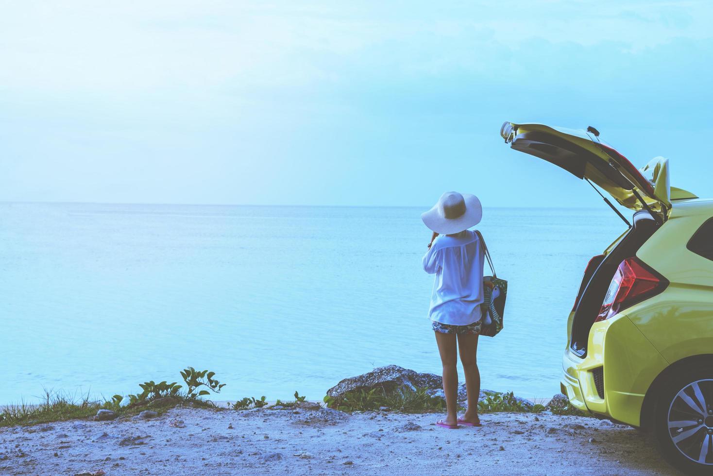 femme asiatique voyage nature. voyager se détendre. se tenir près de la voiture photo