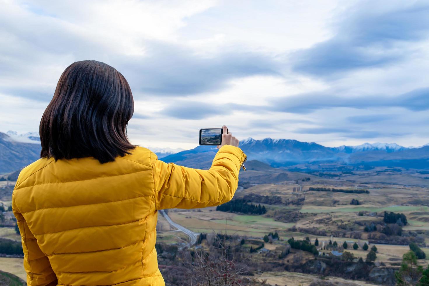 Femme de tourisme asiatique prenant une photo avec un téléphone portable à Queenstown, île du sud, Nouvelle-Zélande