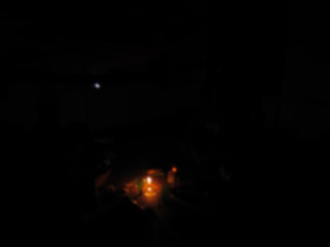 défocalisé sur une bougie allumée illumine la pièce la nuit photo