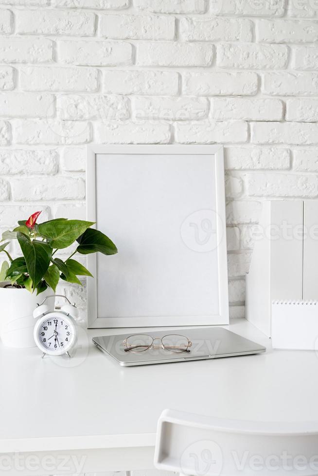 vue de face de l'agencement du bureau avec calendrier vierge pour maquette, dossiers papier et cadre blanc avec espace de copie photo