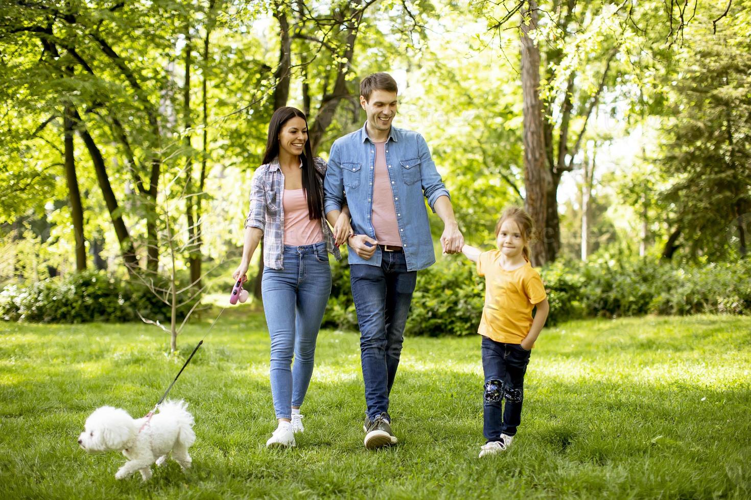 famille heureuse avec un chien bichon mignon dans le parc photo