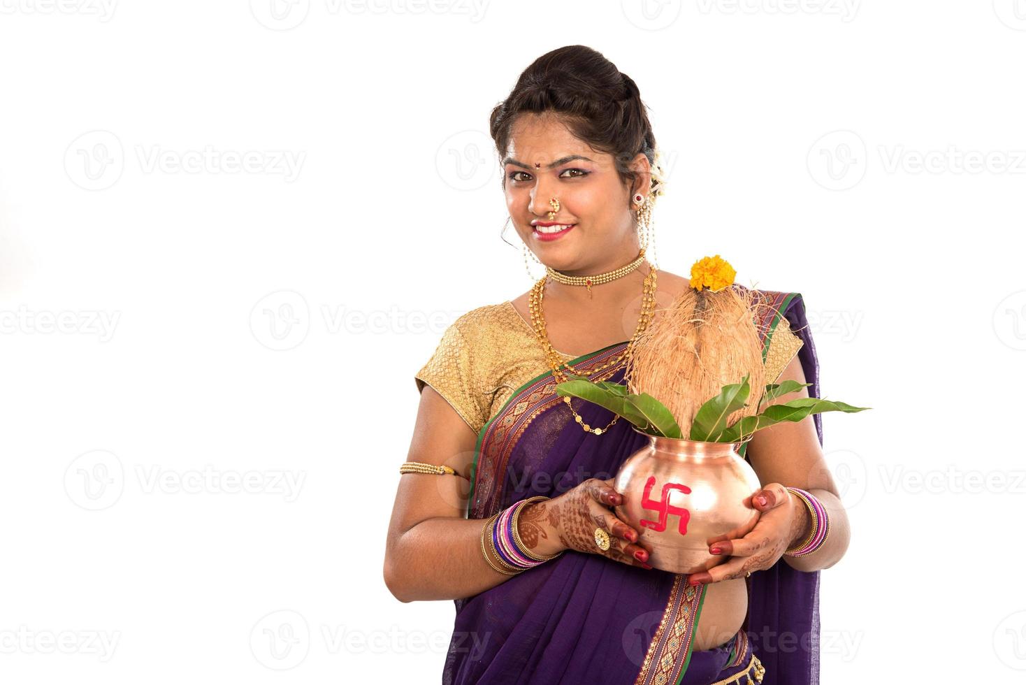 femme traditionnelle indienne tenant un kalash traditionnel en cuivre, fête indienne, kalash en cuivre avec feuille de noix de coco et de mangue avec décoration florale, essentiel dans la puja hindoue. photo