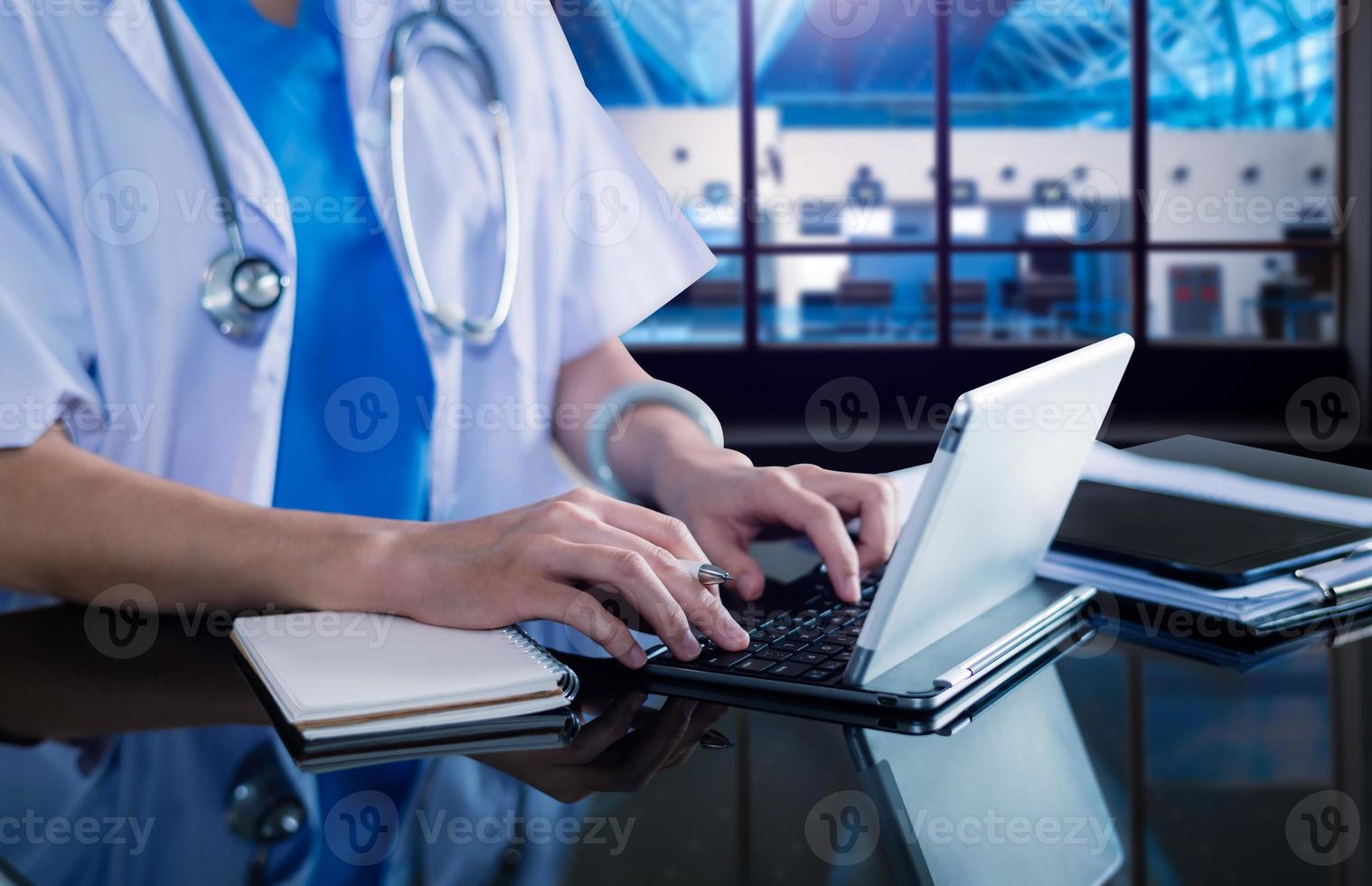 concept de technologie médicale. médecin travaillant avec un téléphone portable et un stéthoscope et un ordinateur portable à tablette numérique dans un bureau moderne photo