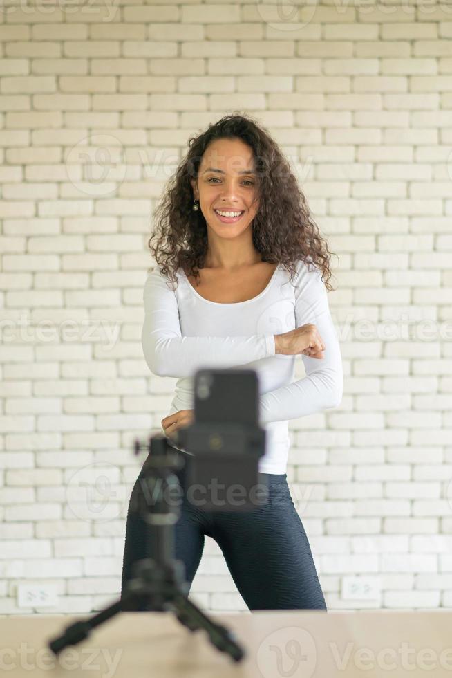 une femme latine a créé sa vidéo de danse avec l'appareil photo d'un smartphone. pour partager la vidéo à l'application de médias sociaux.