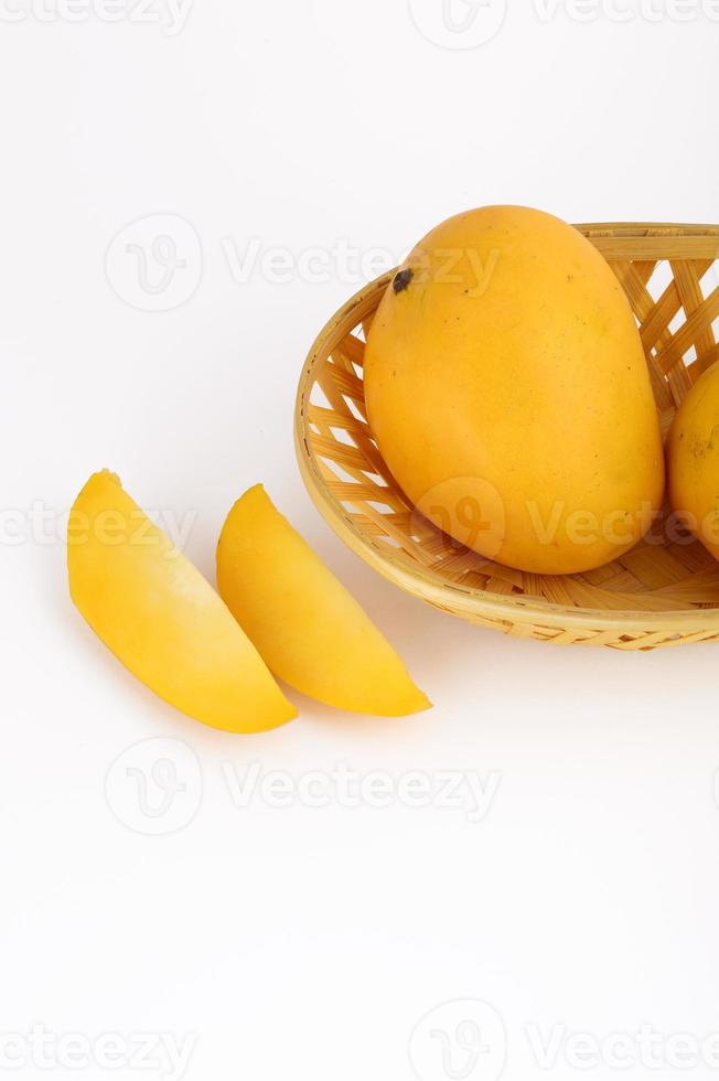 Fruits de mangue dans le panier avec tranche sur fond blanc photo