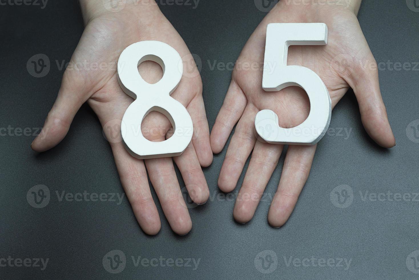 aux mains féminines le chiffre de quatre-vingt-cinq. photo