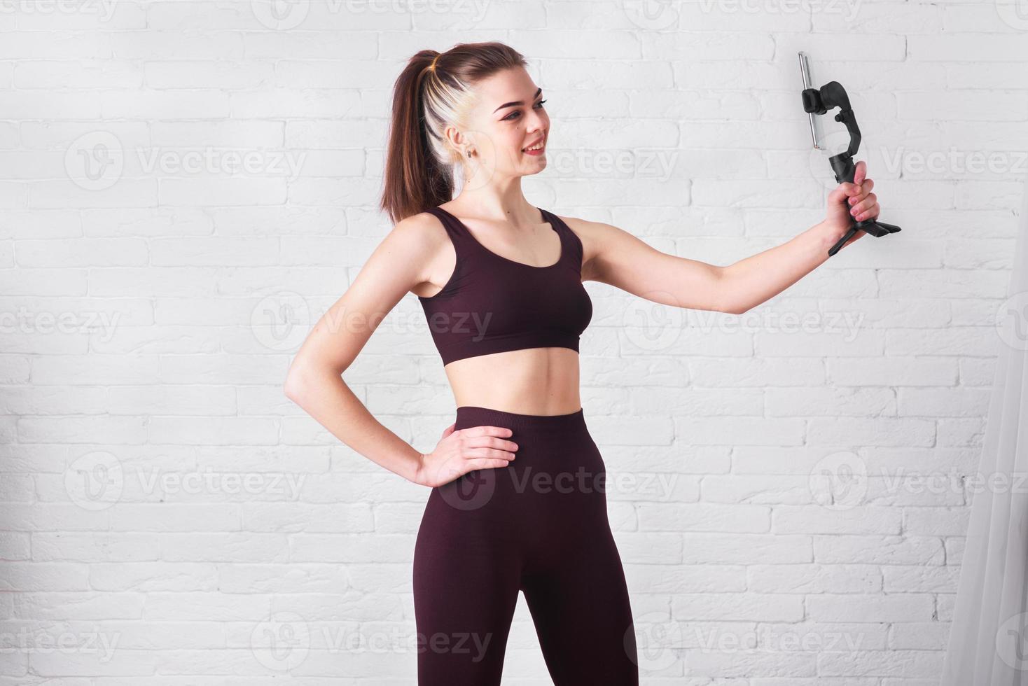 la fille est engagée dans le fitness à la maison. formation au chat vidéo interactif. profession sportive en ligne photo