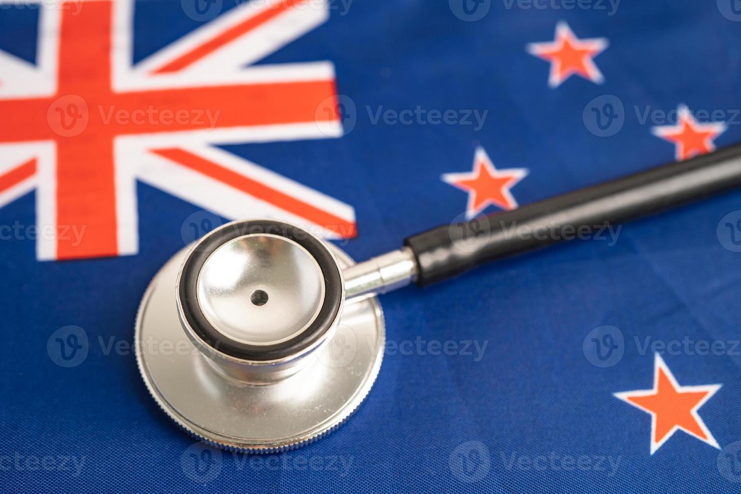 stéthoscope noir sur fond de drapeau de la Nouvelle-Zélande, concept commercial et financier. photo
