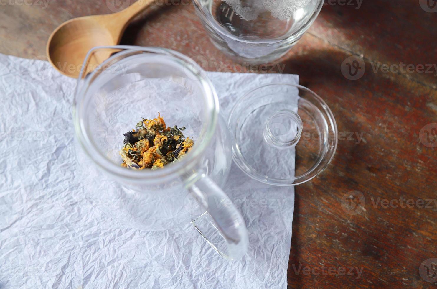 feuille de cannabis avec thé aux fleurs dans un bocal en verre pour une boisson aromatique saine photo