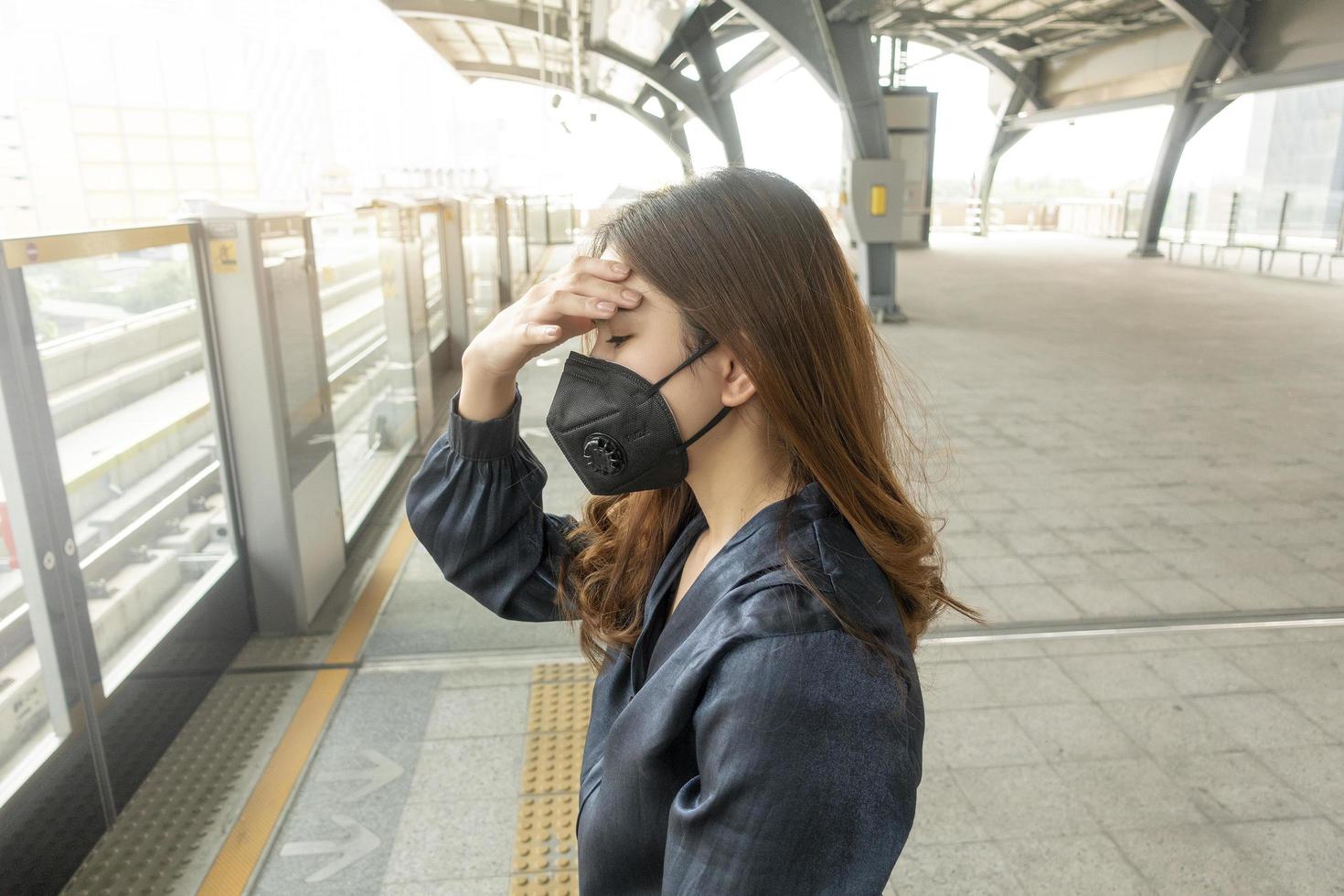 belle femme portant un masque anti-poussière protège la pollution de l'air et pm 2,5 sur la ville de la rue photo