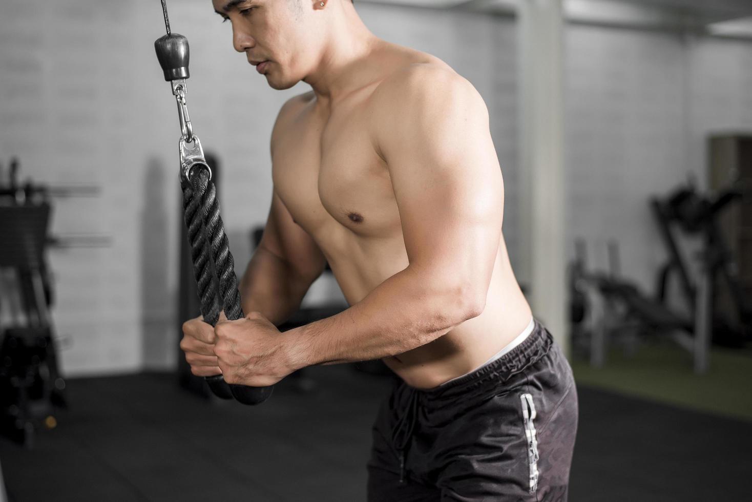 Le bodybuilder de l'homme de remise en forme musculaire est une séance d'entraînement dans une salle de sport photo