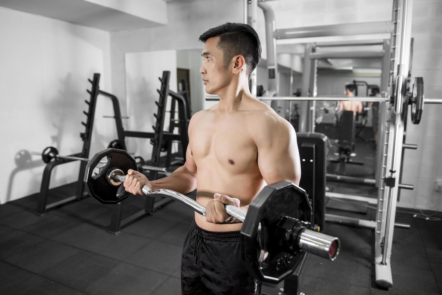 Le bodybuilder de l'homme de remise en forme musculaire est une séance d'entraînement dans une salle de sport photo