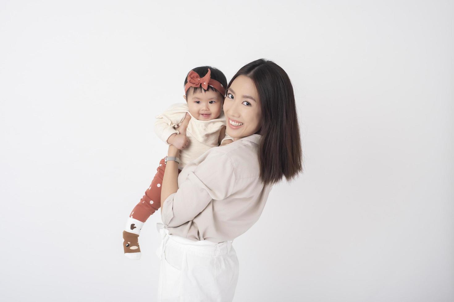 mère asiatique et adorable petite fille sont heureuses sur fond blanc photo